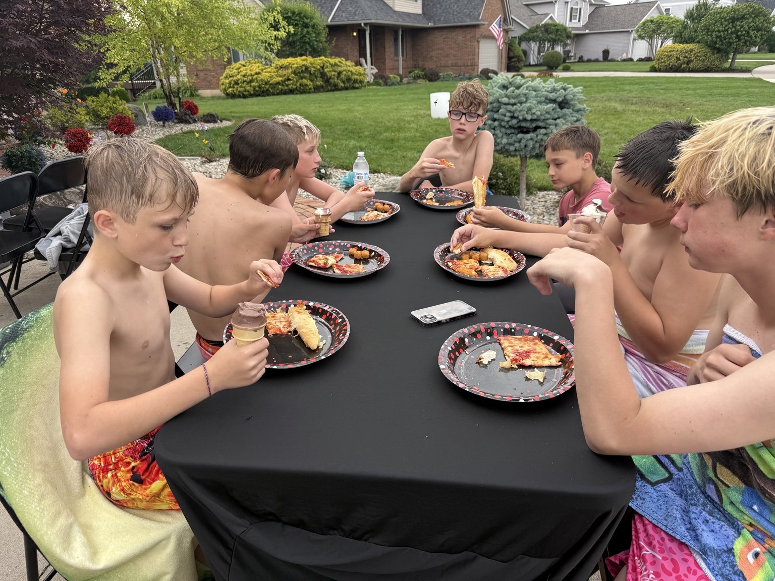 Kids eating pizza and ice cream at a pool party